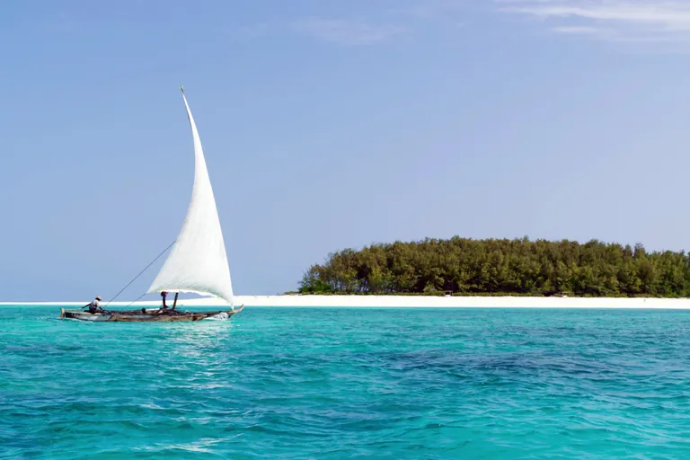 Traditional dhow with a white sail near Mnemba Island, Zanzibar